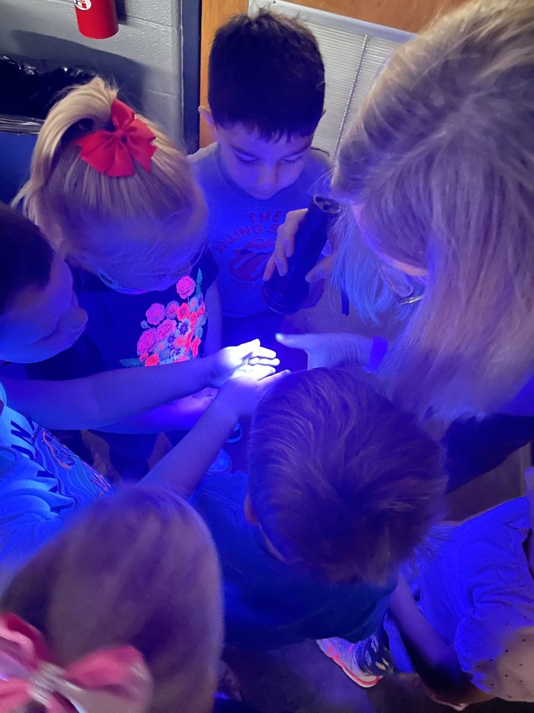 Mrs. Trecker demonstrates blue light technology to emphasize the importance of handwashing.